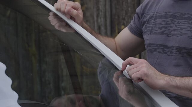 Male person in reflection check the fractured windscreen on the car 4K