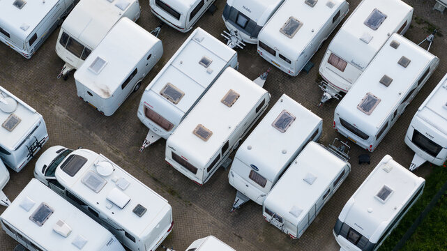 Purmerend, Netherlands - 15 June 2026: Aerial view of numerous white caravans parked in neat rows on a paved lot, showcasing organized storage for recreational vehicles.