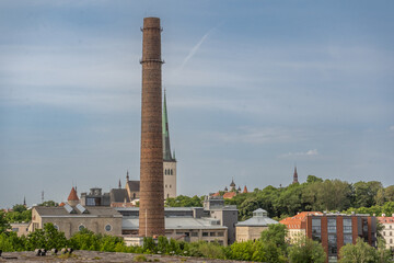 Fototapeta premium Urban panorama of Tallinn showcasing the contrast between industrial heritage structures and the medieval skyline of Estonia's capital.