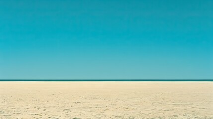Fototapeta premium Vast, empty beach under a clear blue sky