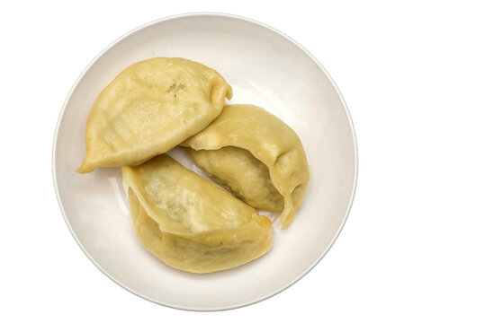 Momos or gyoza on a white plate with copy space.