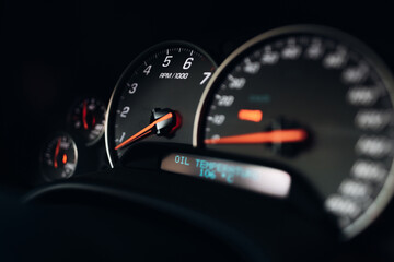 Fototapeta premium Sports car tachometer and dashboard with backlight. Close-up view of the modern car dashboard. Arrow of speedometer of supercar 
