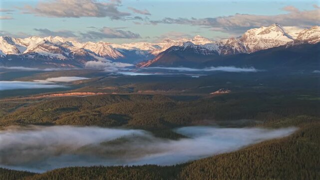 Forward panning drone shot of Canadian Rockies fog inversion