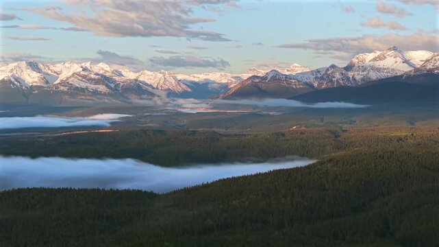 Sideways panning drone shot of Canadian Rockies morning fog
