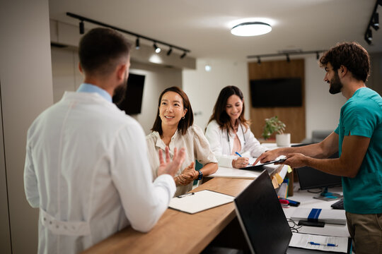 Healthcare professionals assisting patient at clinic reception desk