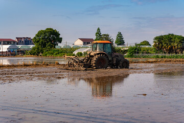 A farm tractor is plowing the field. © Hummingbird