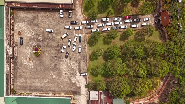 Top-down timelapse footage captured at the Pastoral Center of the Diocese of Buon Ma Thuot, Dak Lak, Vietnam. The parking area gradually fills with motorcycles and cars arriving for a major religious 