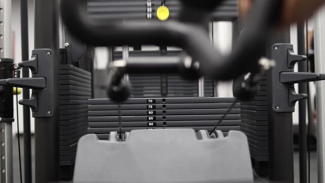 Close view of person pulling neutral grip handle on cable machine during strength workout focused resistance training targeting back muscles and upper body power