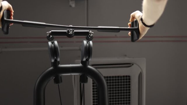 Person performs seated cable row on resistance machine focusing on back muscles and controlled technique during strength workout building endurance and posture