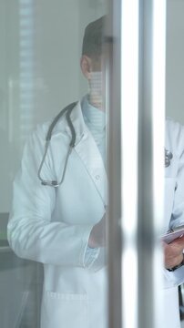 Healthcare professional wearing a white lab coat and stethoscope, analyzing medical records with focus, embodying clinical expertise and patient care values