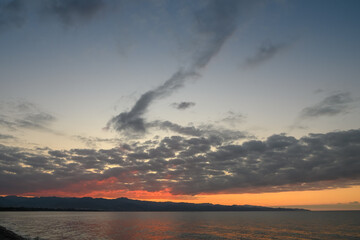 Fototapeta premium Breathtaking sunset over tranquil waters with dramatic clouds reflecting vibrant colors