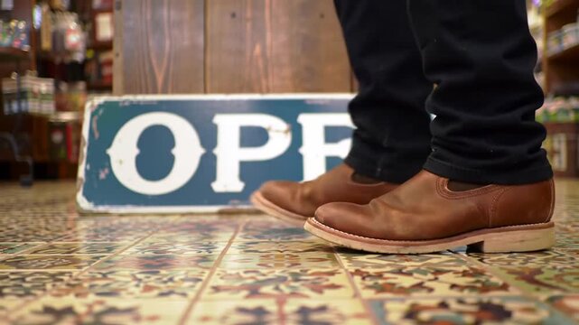 Person in boots walks past an open sign in a vintage store