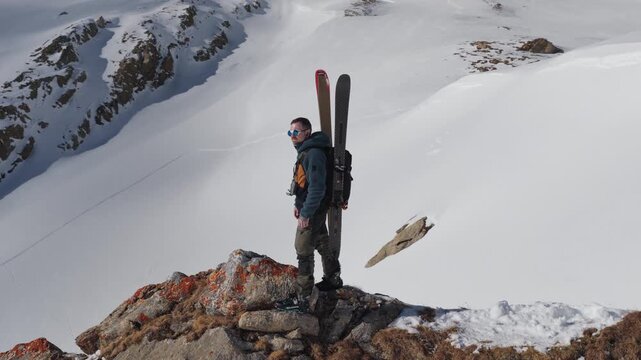  4K 59.94fps Cinematic drone orbit around a ski mountaineer on a rocky summit in Flims Laax, Swiss Alps, surrounded by rugged alpine terrain and snow-covered peaks.