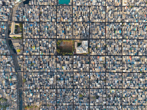 Aerial view of the dense urban layout of Malvani with tightly packed rooftops and a central open space in Mumbai, Maharashtra, India.