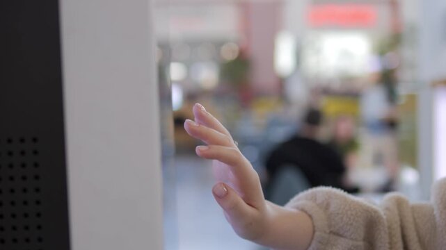 Small child gently touches a glass surface. The child's hand is soft and curious. Background is softly blurred with warm, inviting colors. This captures early childhood wonder and discovery