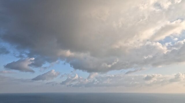 Clouds Ocean Sky moving white and gray clouds over a vast blue ocean horizon during daytime