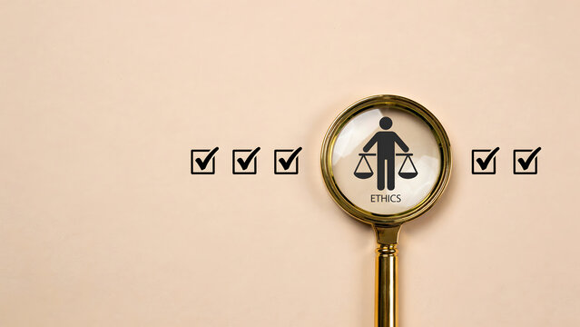 Magnifying glass over an icon of a person holding scales representing ethics