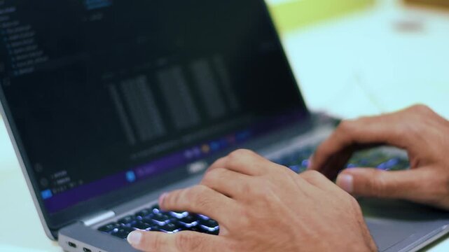 Hands Typing Code on Laptop Keyboard