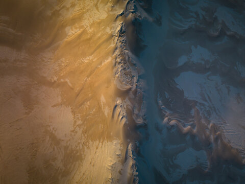 Aerial view of the sandy dunes and coastal landscape of Two Peoples Bay Nature Reserve, featuring textured golden sand patterns meeting the ocean in Nanarup, Western Australia, Australia.
