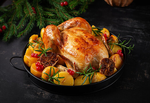 Golden Roasted Chicken with Potatoes and Rosemary on Festive Holiday Table