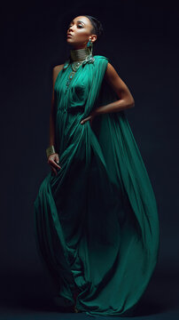 Stylish individual showcasing elaborate jewelry and fashionable apparel in studio setting