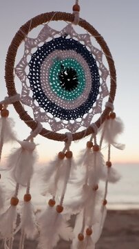 Dreamcatcher feathers beads sunset beach ocean boho decor closeup vertical reel background