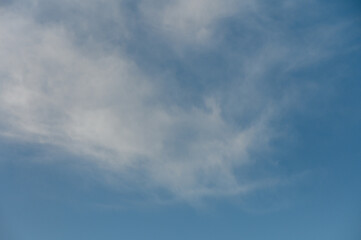 Fototapeta premium Endless azure sky with wispy clouds drifting lazily on a warm summer day