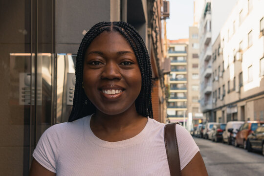 Young black woman smiling on city street
