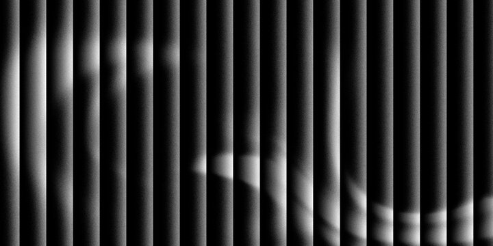 Light passing through venetian blinds, casting stripes of light and shadow with subtle hints of color.