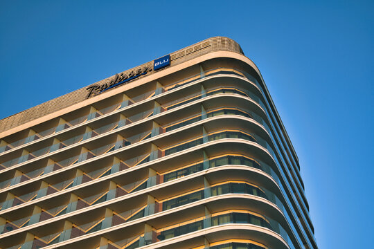 Radisson Blu Modern Curved Hotel Facade With Glass Balconies Against Clear Blue Sky - the seaside town of Świnoujście.