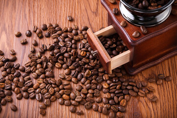 Roasted Coffee Beans and Vintage Manual Grinder on Wooden Table © HoangVan