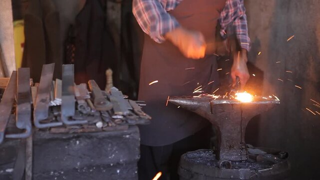 Blacksmith forging incandescent hot metal on an anvil in a dark workshop. Cinematic sparks.