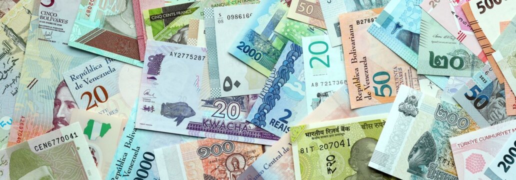 Big amount of money bills of various currencies. Assortment background of international cash