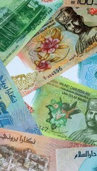 Brunei dollar money banknotes bunch on table. Brunei bills of BND currency close up © Larysa