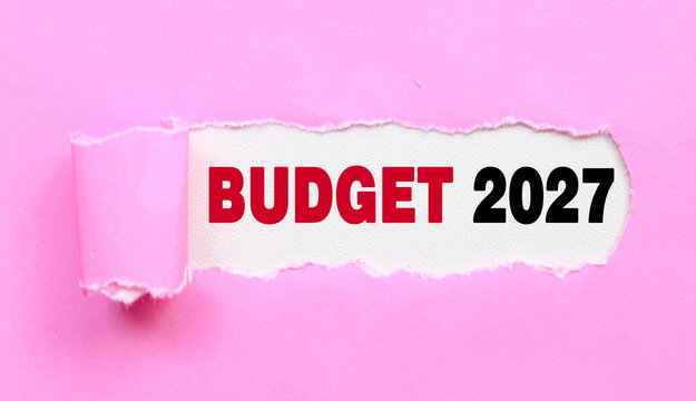 Torn pink paper revealing Budget 2027 text underneath. Tax 2027 Business investment strategy, and budgeting ideas for 2027. New Year coming concept.