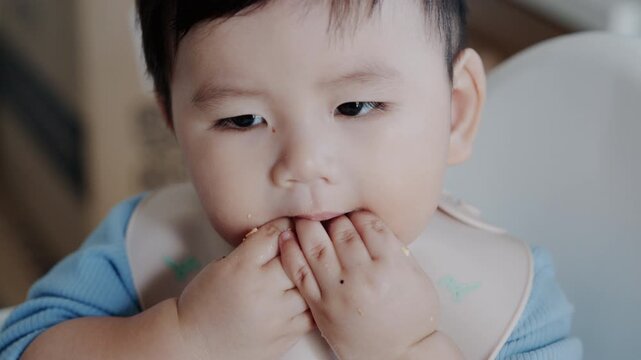 Cute Asian Toddler Eating Finger Food at Home, Healthy Childhood and Family Lifestyle in 4K