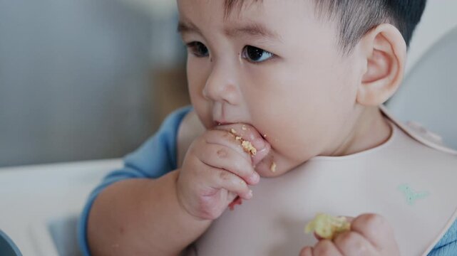 Cute Asian Toddler Eating Finger Food at Home, Healthy Childhood and Family Lifestyle in 4K
