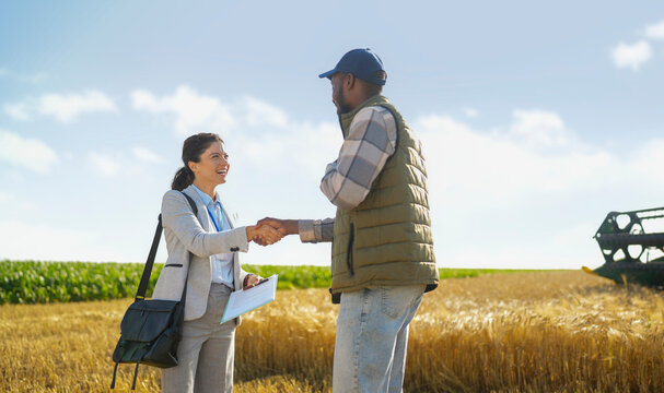 Farmer and insurance advisor shaking hands after discussing crop protection and agricultural risk management solutions.