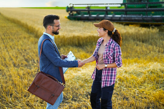 Agricultural advisor and farmer shaking hands after discussing grant funding and support programs.