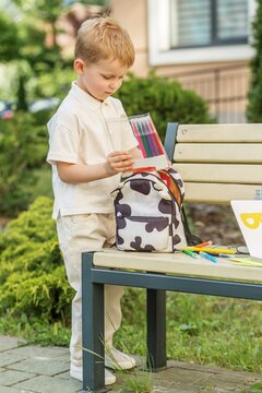 Back to School Preparation Child Packing Backpack With School Supplies