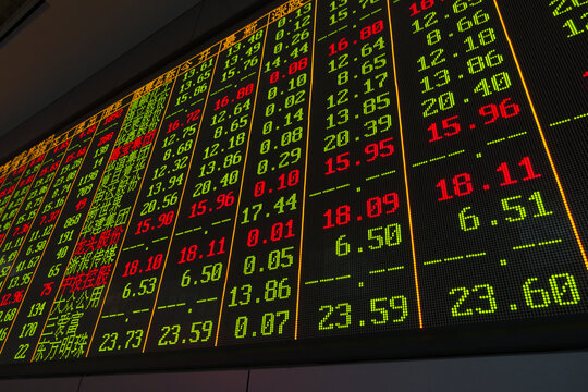 Stock market price board with red and green share data at an Asian financial exchange