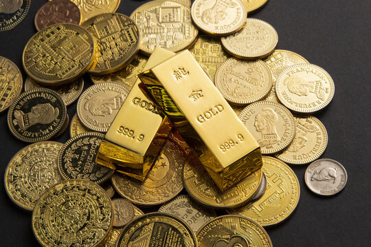 Gold bars on assorted coins representing wealth and investment