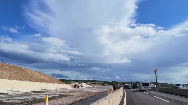 Winchester Hampshire UK. 04.06.2026. Video. Vehicles navigate a busy highway section undergoing significant construction with earthmoving equipment visible on the side along the A34 and M3 motorway.