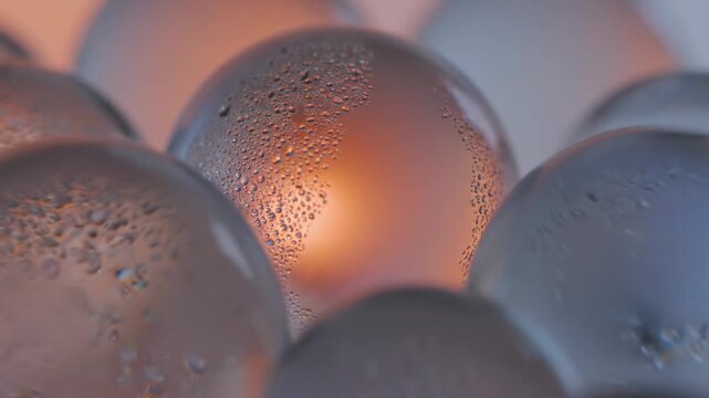 Close up view of small glass balls with water droplets and lights in the background during nighttime