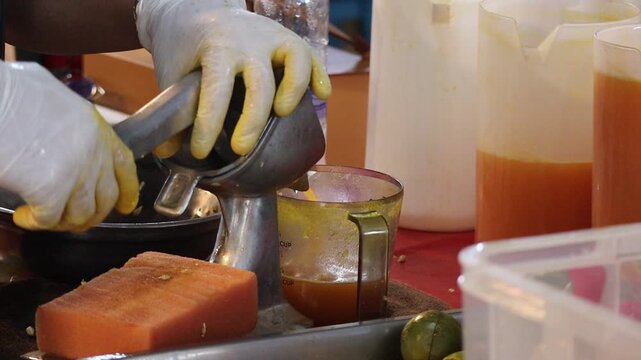 Street Food Vendor Using a Manual Citrus Press to Make Fresh Juice