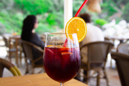 Glass of refreshing sangria with fresh fruit on a table at a beachfront bar. Summer holiday atmosphere, relaxation by the sea, travel and leisure concept.