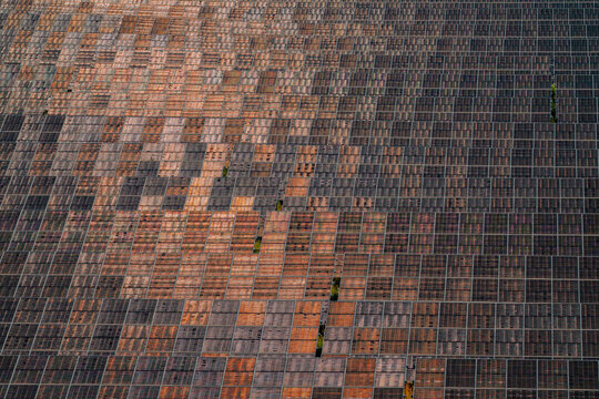 Aerial view of a large solar farm with rows of photovoltaic panels reflecting sunlight in Saint-Denis-de-l'Hotel, Centre-Val de Loire, France.