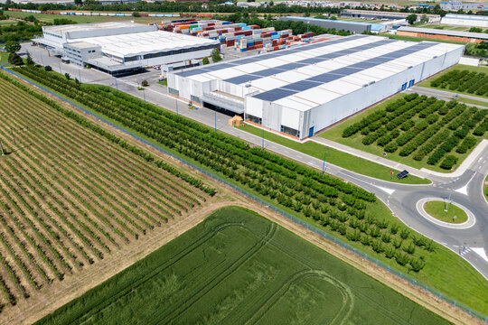 Aerial view of a modern logistics center with solar panels on the roof