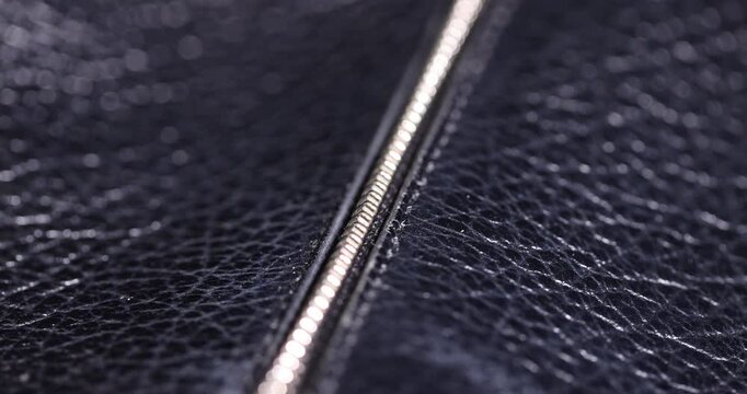 details of a natural black leather bag after prolonged use, details and pieces of natural leather used for the production of items, shadow