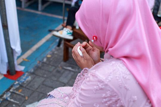 over-the-shoulder shot of a Muslim girl wearing a pink satin hijab